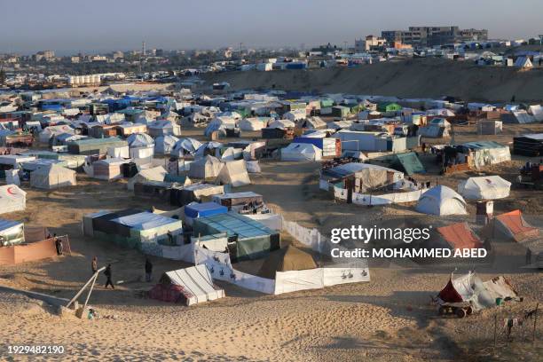 Displaced Palestinians take shelter in a makeshift tent camp by the beach in Rafah near the border with Egypt in the southern Gaza Strip on January...