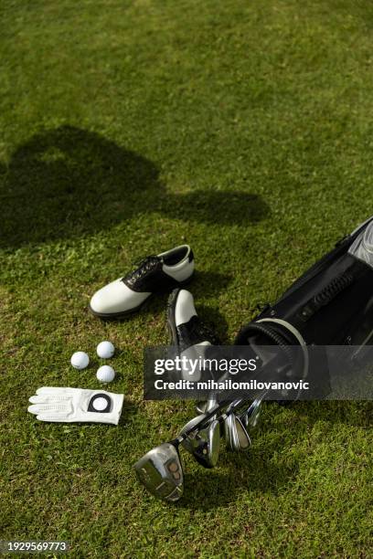der schatten des golfers über der golfausrüstung - accessoires stock-fotos und bilder