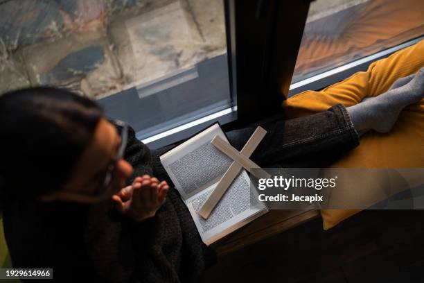 woman praying at home - trust god stock pictures, royalty-free photos & images