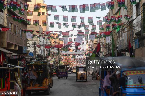 Commuters move past the Pakistan People's Party flags hung over a street in Karachi on January 16 ahead of the country's upcoming general elections.