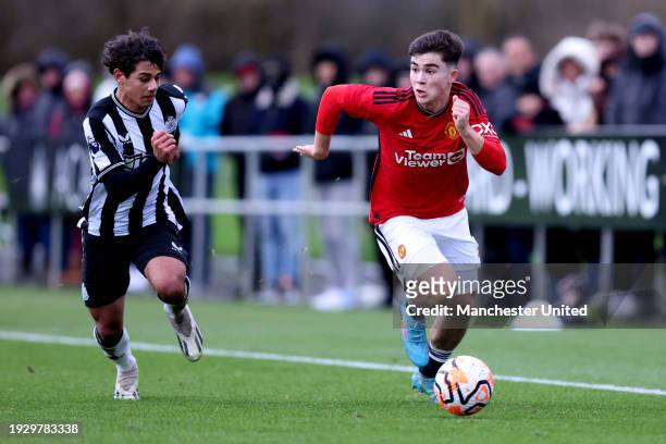 Harry Amass of Manchester United U18 runs with the ball whilst under pressure from Matheos Ferreira of Newcastle United U18 during the U18 Premier...