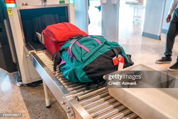 backpack and carry on luggage coming out of baggage scanner - airport authority stock pictures, royalty-free photos & images