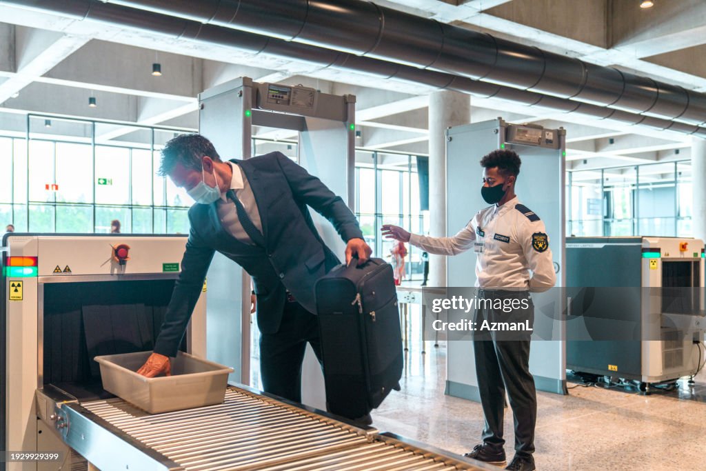Asian Flyer With Face Mask Collecting Bags at Security