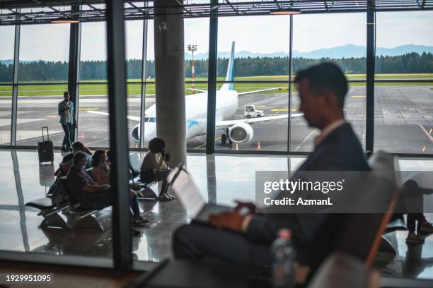 asian businessman in a business lounge at the airport - airport departure area stock pictures, royalty-free photos & images