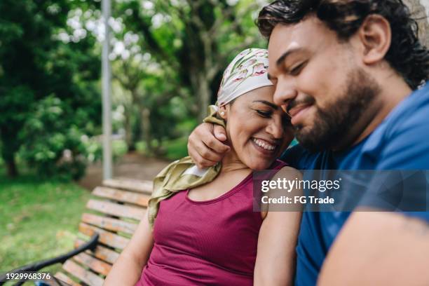 couple embracing at park - cancer stock pictures, royalty-free photos & images