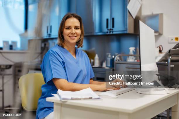 young beautiful female doctor working on computer in doctor's office. physician doing paperwork and administrative tasks. - dermatology stock pictures, royalty-free photos & images