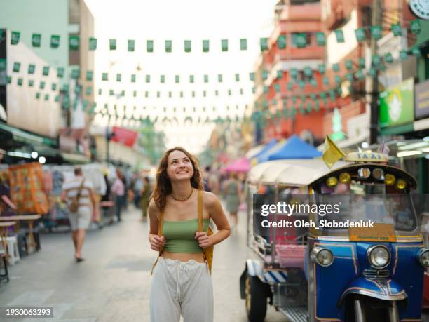 woman exploring khao san road in bangkok during vacation - rugzaktoerist stockfoto's en -beelden