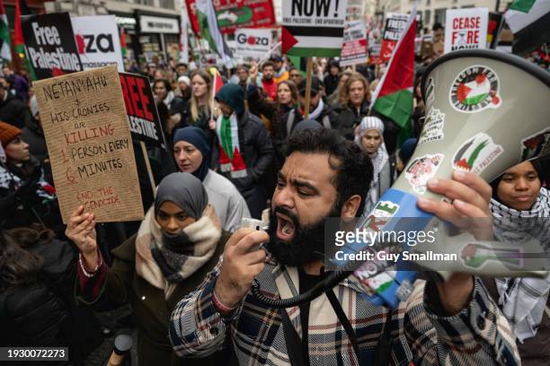 An activist shouts into a megaphone as hundreds of thousands of people join the protest in London on January 13, 2024 in London, England. Activists...