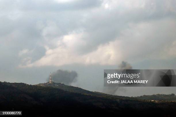 This picture taken from an Israeli position along the border with southern Lebanon shows smoke billowing above the Lebanese village of Hula during...