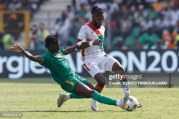Mauritania's defender Ibrahima Keita tackles Burkina Faso's defender Steeve Yago during the Africa Cup of Nations 2024 group D football match between...