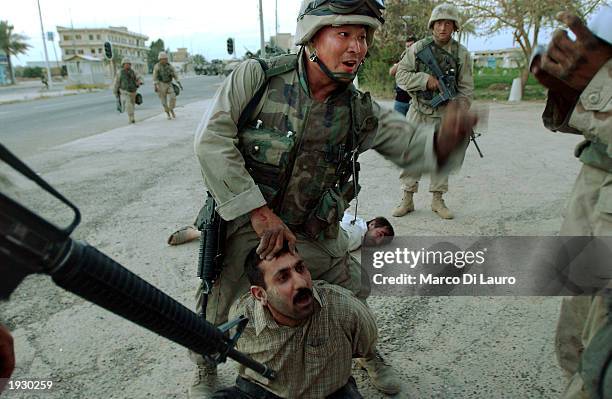 Marines arrest an Iraqi prisoner of war after a scuffle in the main Square of Tikrit, April 14, 2003 some175 kilometers - just over 100 miles - north...