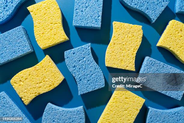 blue and yellow cleaning sponges flat lay on blue background - spugna per le pulizie foto e immagini stock