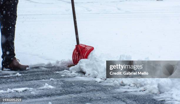 man cleaning the sidewalk covered in snow - quitanieves fotografías e imágenes de stock