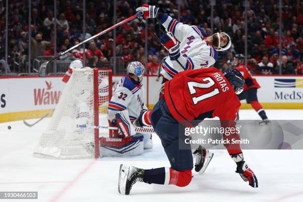 Aliaksei Protas of the Washington Capitals collides with K'Andre Miller of the New York Rangers during the second period at Capital One Arena on...