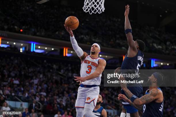 Josh Hart of the New York Knicks shoots the ball against Anthony Edwards and Nickeil Alexander-Walker of the Minnesota Timberwolves at Madison Square...