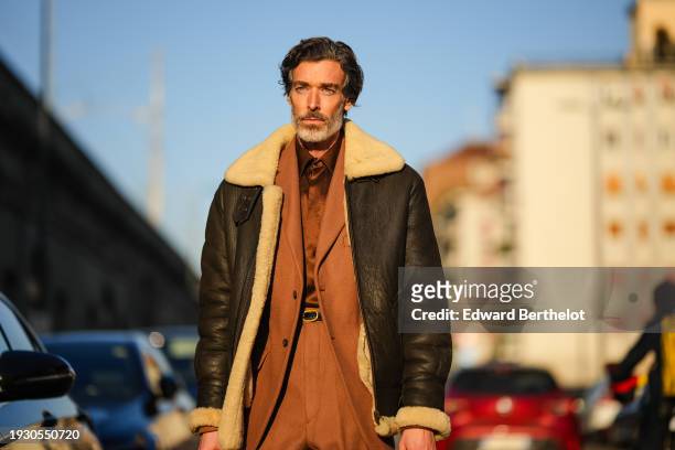 Richard Biedul wears a brown aviator jacket, a brown blazer jacket, matching suit pants, a belt, outside Jordanluca, during the Milan Fashion Week -...