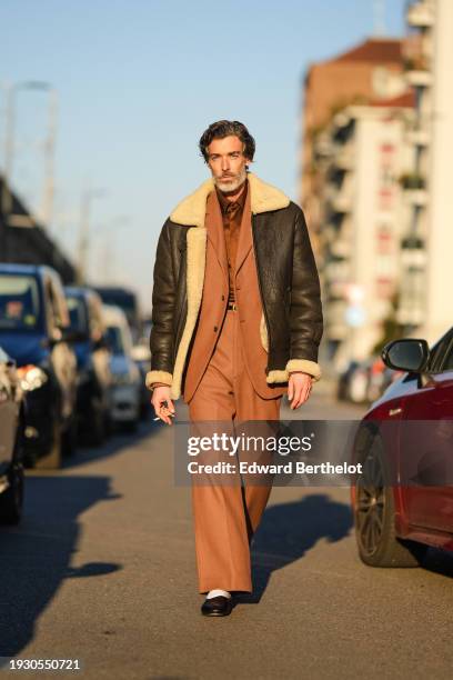 Richard Biedul wears a brown aviator jacket, a brown blazer jacket, matching suit pants, a belt, shoes, outside Jordanluca, during the Milan Fashion...