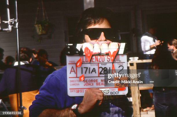 Crew member Bobby Mancuso holds up a clapboard, from the film 'Lorenzo's Oil' , decorated for Halloween , Pittsburgh, Pennsylvania, October 31, 1991.