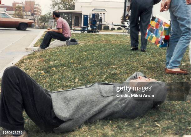 American film director James Ivory lies on the grass between takes on the set of his film 'The Bostonians', Cambridge, Massachusetts, 1983.