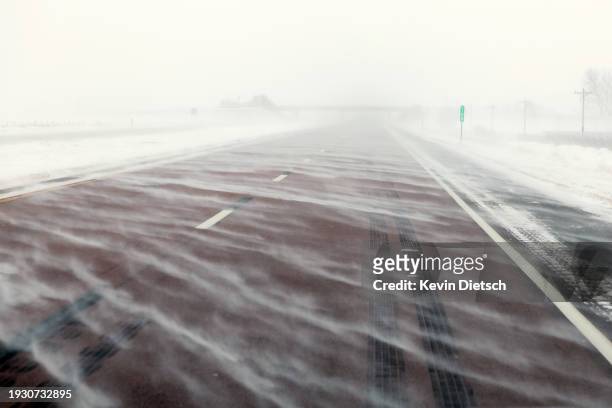 Snow blows over I-25 during blizzard like conditions on January 13, 2024 in Crescent, Iowa. The second winter weather system in a week is bringing...