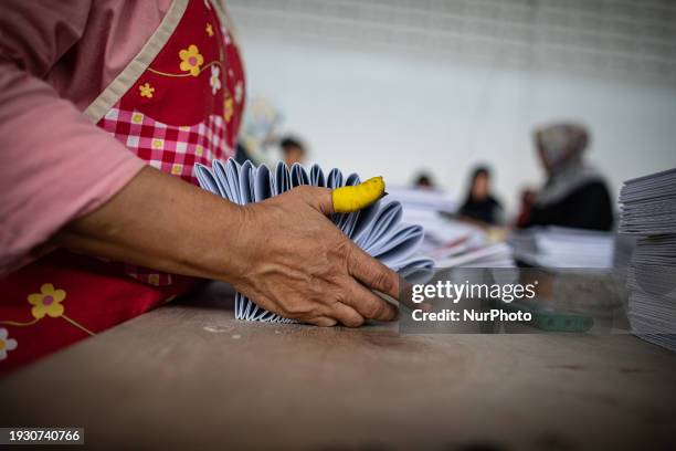 Workers are sorting and folding ballot papers for the upcoming general elections at a logistics warehouse in Jakarta, Indonesia, on January 16, 2024....