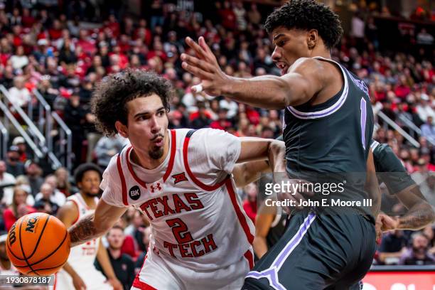 Pop Isaacs of the Texas Tech Red Raiders looks to pass around David N'Guessan of the Kansas State Wildcats during the second half of the game at...