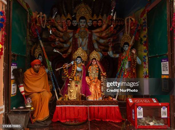 Priest is sitting beside idols of Hindu deities in a temple in Ayodhya, India, on January 16, 2024.