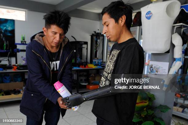 Electrical engineer and robotics expert Roly Mamani explains the operation of the bionic arm prosthesis to Marco Antonio Nina in the town of...