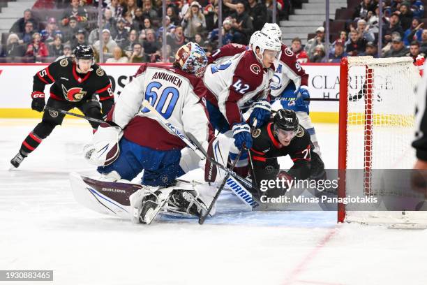 Goaltender Justus Annunen of the Colorado Avalanche looks behind him as Ridly Greig of the Ottawa Senators tips the puck into the net during the...