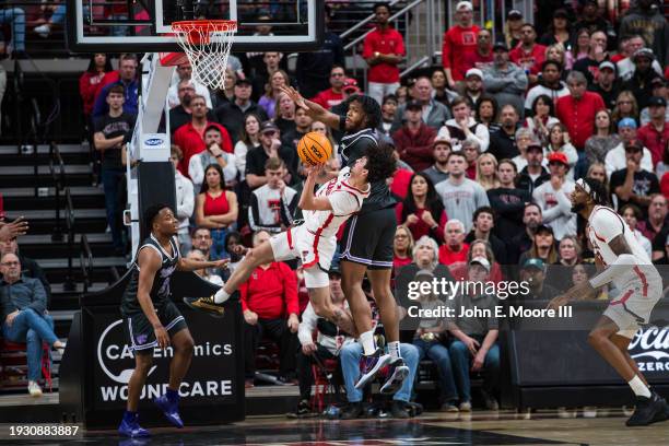 Pop Isaacs of the Texas Tech Red Raiders twists to shoot against Will McNair Jr. #13 of the Kansas State Wildcats during the second half of the game...