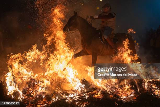Horse rider jumps over a bonfire during the traditional "Las Luminarias" celebration. Each year, horse riders jump over bonfires during the...
