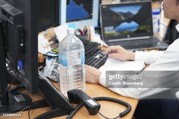 Litter bottle of water and a pack of cough drops on a desk of call loan broker at the trading floor of Tokyo Tanshi Co. In Tokyo, Japan, on...