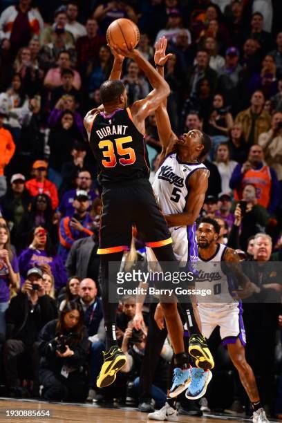 January 16: Kevin Durant of the Phoenix Suns shoots the ball while De'Aaron Fox of the Sacramento Kings goes up for the block during the game on...
