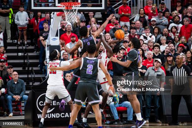 Joe Toussaint of the Texas Tech Red Raiders is fouled by David N'Guessan of the Kansas State Wildcats while shooting the ball during the second half...