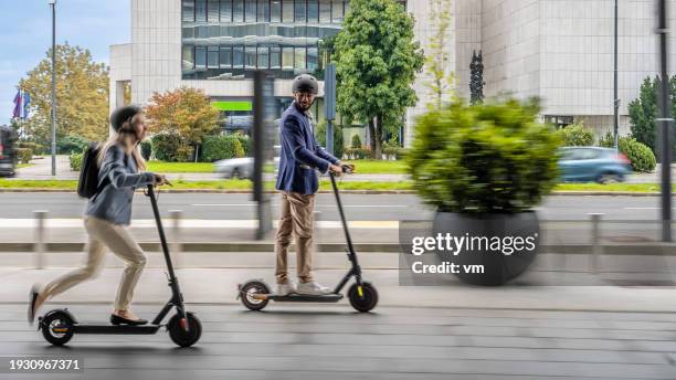 smiling couple riding electric scooter - scooter city fotografías e imágenes de stock