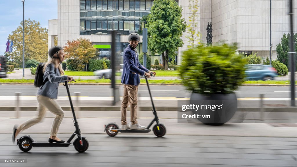 Smiling couple riding electric scooter