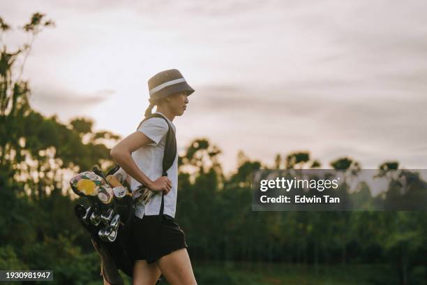 confidence asian chinese female golfer walking in golf course - golfer walking stock pictures, royalty-free photos & images