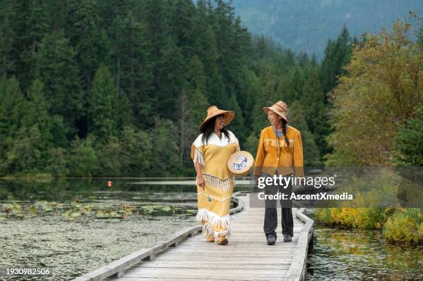 indigenous women walk along boardwalk - canadian culture stock pictures, royalty-free photos & images