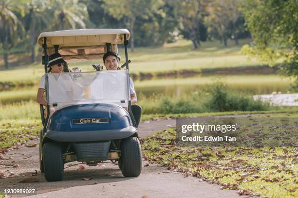 2 happy asian chinese golfers driving golf cart in golf course weekend morning - driving golf cart stock pictures, royalty-free photos & images