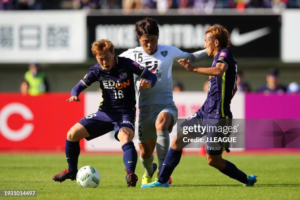 Toshiya Sueyoshi of Avispa Fukuoka competes for the ball against Kohei Shimizu and Yoshifumi Kashiwa of Sanfrecce Hiroshima during the J.League J1...