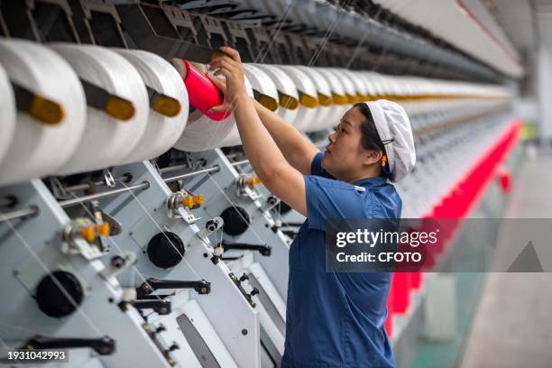 Textile worker works at the production line of Jiangsu Tongxin Chemical Fiber Co., Ltd. In Taizhou, East China's Jiangsu province, Sept. 29, 2023....