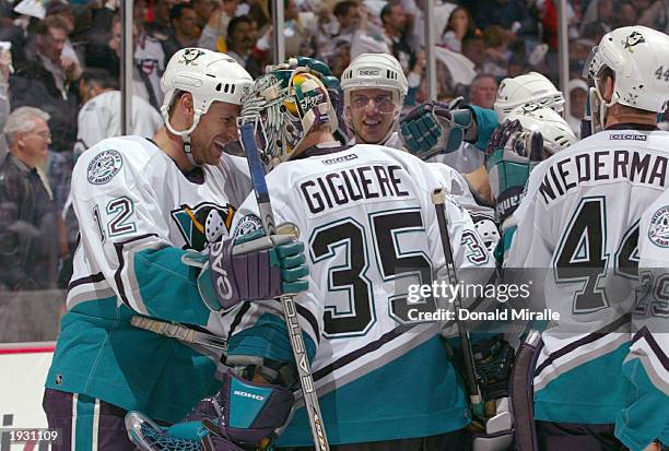 Goalie Jean-Sebastien Giguere of the Mighty Ducks of Anaheim celebrates victory with teammates after game 3 against the Detroit Red Wings during...