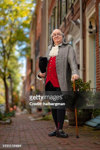 Full Body Portrait of Benjamin Franklin Impersonator Standing Next to Building with Hat and Walking Cane