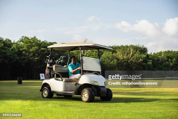 using golf cart - golf caddy stockfoto's en -beelden