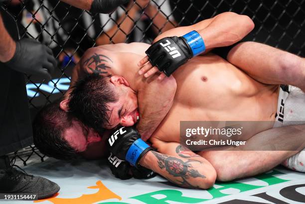 Jim Miller secures a submission against Gabriel Benitez of Mexico in a lightweight fight during the UFC Fight Night event at UFC APEX on January 13,...