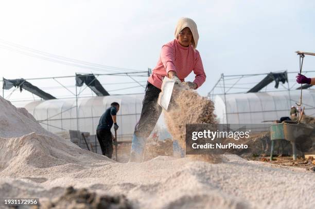Workers are working at the construction site of a greenhouse for passion fruit cultivation in Congjiang County, Southwest China's Guizhou Province,...