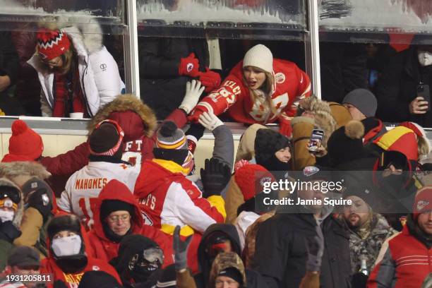 Taylor Swift celebrates with fans during the AFC Wild Card Playoffs between the Miami Dolphins and the Kansas City Chiefs at GEHA Field at Arrowhead...