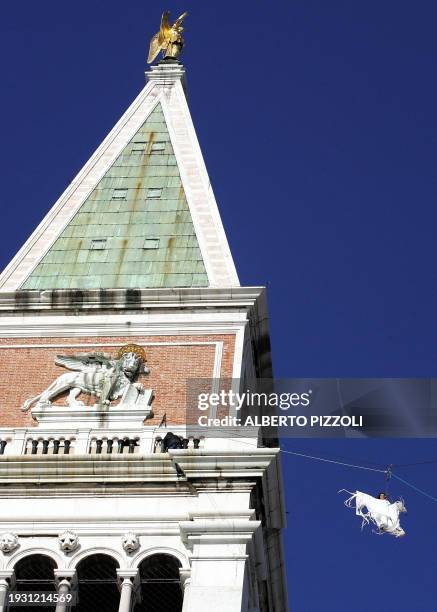 An actress perfoms the "Angel Flight" from the San Marco's bell tower in Venice, 30 January 2005. Venice start its famous carnival with a festival of...