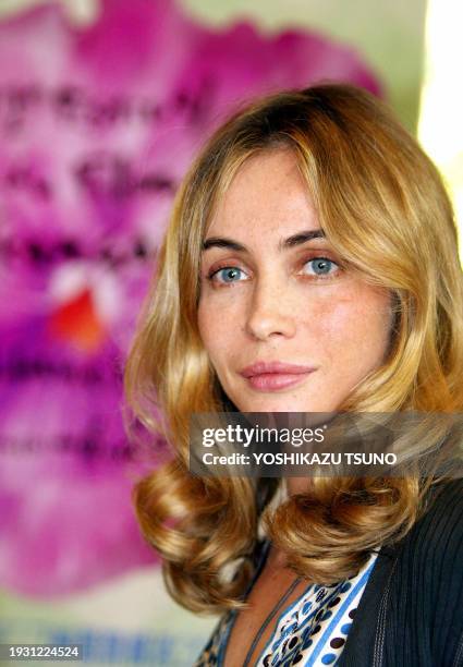 French movie star Emmanuelle Beart smiles before a logo mark of the 12th French Movie Festival in Yokohama as she conducts 50 members of a French...