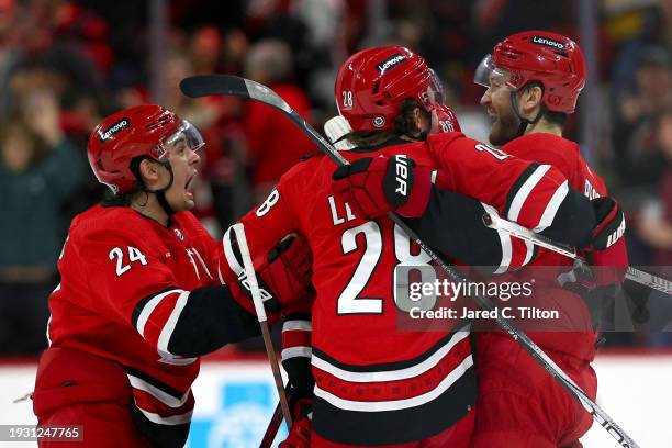 Brett Pesce of the Carolina Hurricanes celebrates with his team after scoring the gaming-winning goal during the overtime period of the game against...